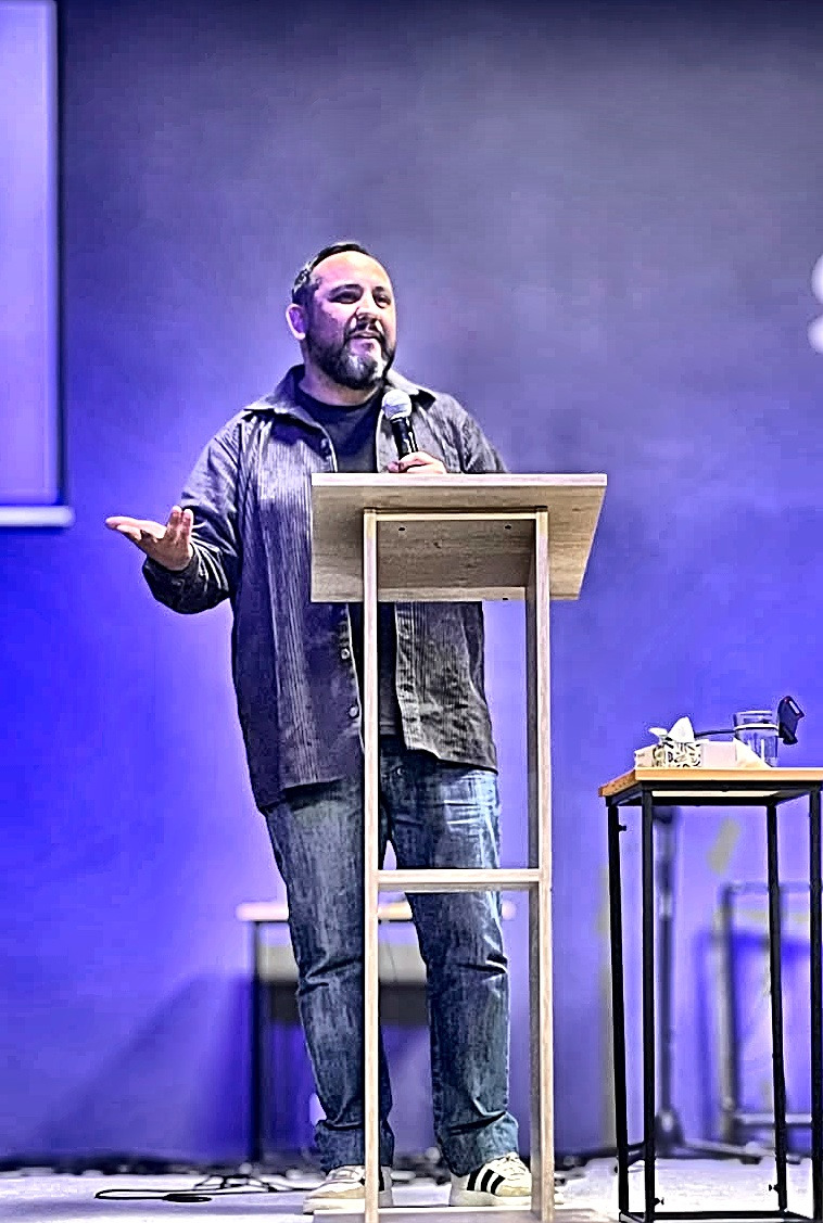 Elías dando una charla presencial, micrófono en mano